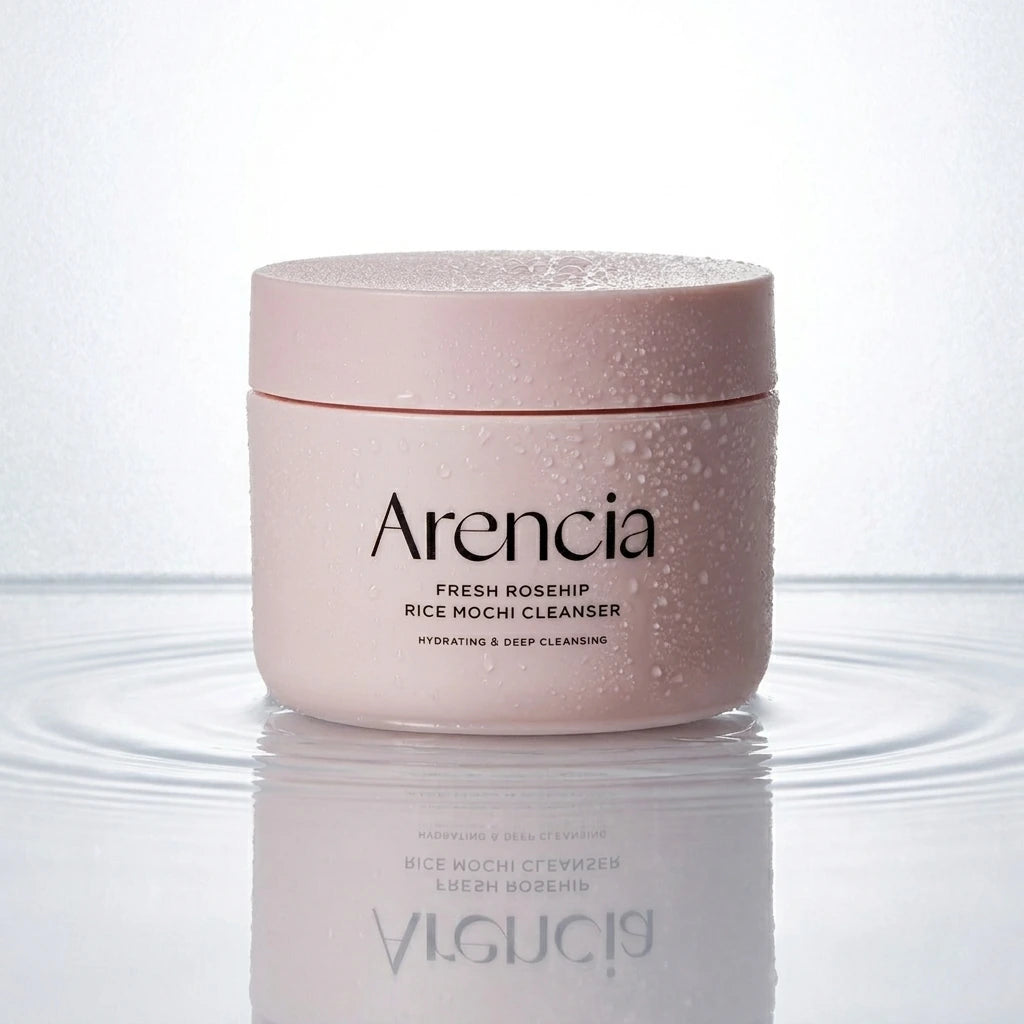 Angle : Prise de vue à ras de terre, l'objectif frôlant le support pour un effet immersif. Scène : Le pot fermé avec son couvercle rose mat se tient au centre d'une fine nappe d'eau cristalline et pure. De subtiles ondulations circulaires entourent sa base. Des micro-gouttelettes de condensation fraîches recouvrent délicatement les parois et le dessus du couvercle. Fond & Lumière : L'arrière-plan est un panneau de verre dépoli rétroéclairé par une lumière blanche purifiante. L'eau crée un reflet net et in