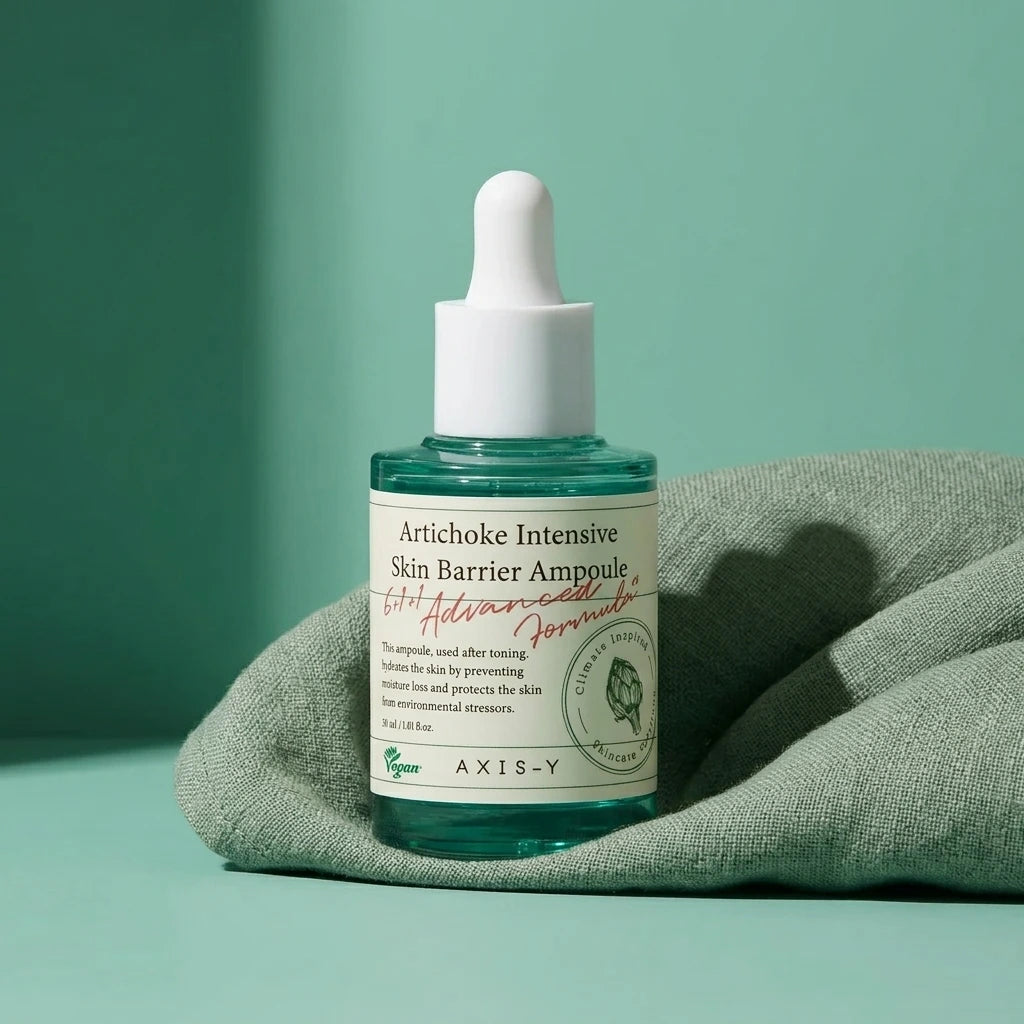 Angle : Prise de vue frontale, géométrique et épurée.  Scène : Le flacon d'ampoule est positionné au centre exact du cadre. Sa base est délicatement enveloppée par un drapé de tissu de lin lourd ou de mousseline de coton couleur vert sauge ou vert bleuté froissé, apportant une texture textile délicate.  Fond & Lumière : Fond ton-sur-ton vert d'eau identique à la bouteille, totalement lisse. La lumière vient de biais de manière ciblée, projetant une ombre graphique longue, nette et étirée du flacon et de sa 