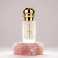 Un plan moyen net et frontal du flacon cylindrique de image_25.png isolé de sa boîte, posé sur un bloc de quartz rose brut et texturé. La lumière de studio traverse le verre dépoli par l'arrière (backlight), révélant de manière réaliste l'opacité blanche et laiteuse du précieux jus de image_25.png. Le bouchon sphérique en or poli capte un éclat lumineux linéaire parfait et éclatant. Style : Photographie cosmétique de haute précision. (gemini-3.1-flash-image-preview)