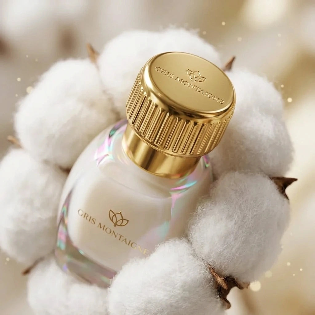 Un plan macro très rapproché concentré sur le bouchon en or poli strié de image_3b1d7b.jpg. Le flacon est niché délicatement au cœur d'une véritable fleur de coton blanche et vaporeuse. Un éclairage irisé subtil crée de fins reflets roses et turquoise sur les contours du verre transparent de image_3b1d7b.jpg. L'arrière-plan présente un flou artistique (bokeh) très doux aux teintes crème et or. Style : Photographie de produit hautement sensorielle. (gemini-3.1-flash-image-preview)