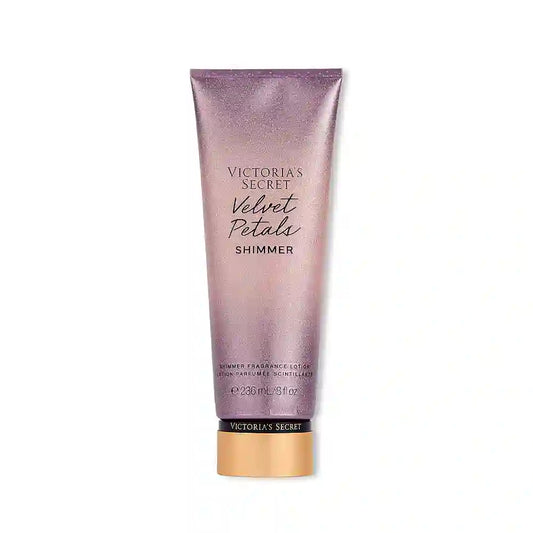 Victoria's Secret Velvet Petals Shimmer Lotion Parfumée frasco con diseño floral y detalles dorados, que emite un suave y luminoso resplandor.